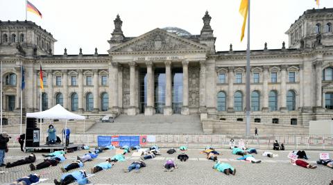 liegende Teilnehmer*innen vor Reichstagsgebäude